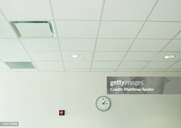 clock on wall in office space - soffitto foto e immagini stock