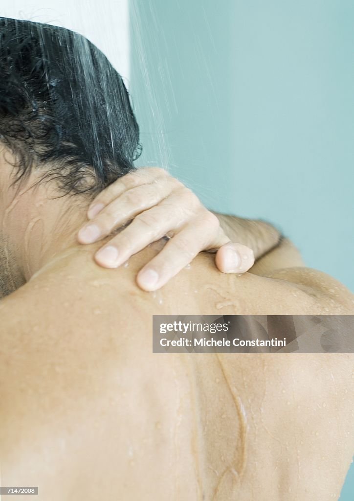 Man touching neck in shower