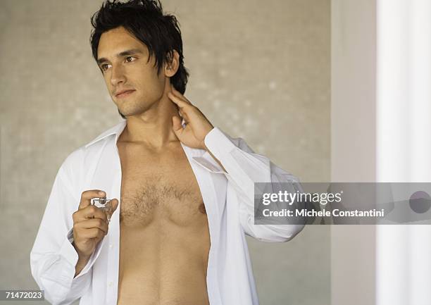 man putting on fragrance - completamente desabrochado fotografías e imágenes de stock