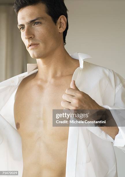 man putting on shirt - completamente desabrochado fotografías e imágenes de stock