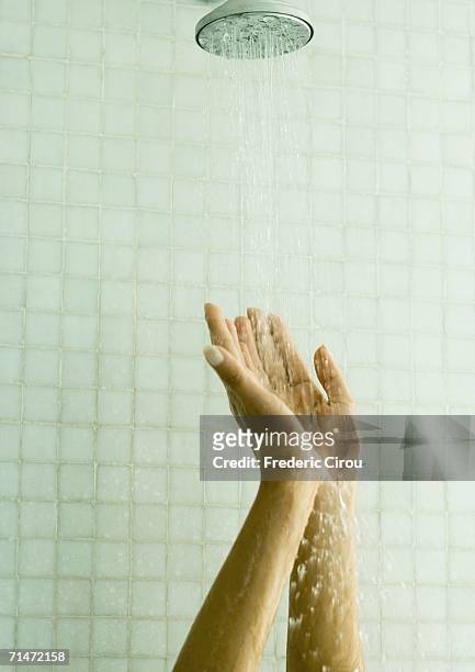 woman holding up hands under shower - spray nozzle stock pictures, royalty-free photos & images