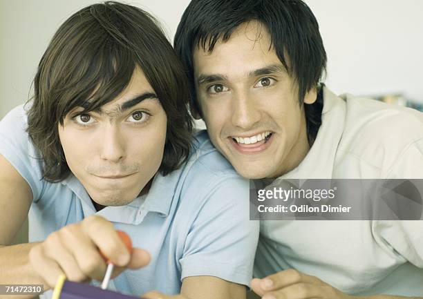 two young men playing video game - nur junge männer stock-fotos und bilder