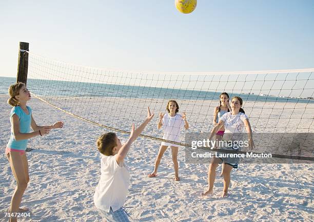 group of kids playing beach volleyball - volleyball player photos et images de collection