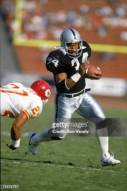Running back Bo Jackson of the Los Angeles Raiders carries the ball against the Kansas City Chiefs during a game at the Los Angeles Memorial Coliseum...