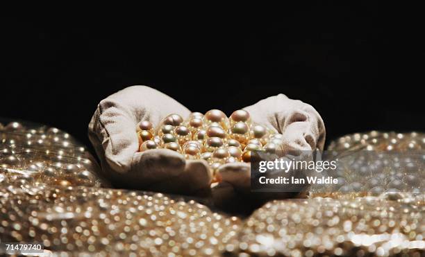 Louise Berg, touring exhibitions co-ordinator for the Australian Museum, holds a portion of a consignment of 6,000 pearls, which are to be added to...