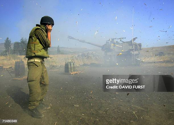 Israel-Lebanon border, ISRAEL: An Israeli soldier covers his ears as a mobile artillery piece fires into Lebanon 19 July 2006 at an Israeli military...