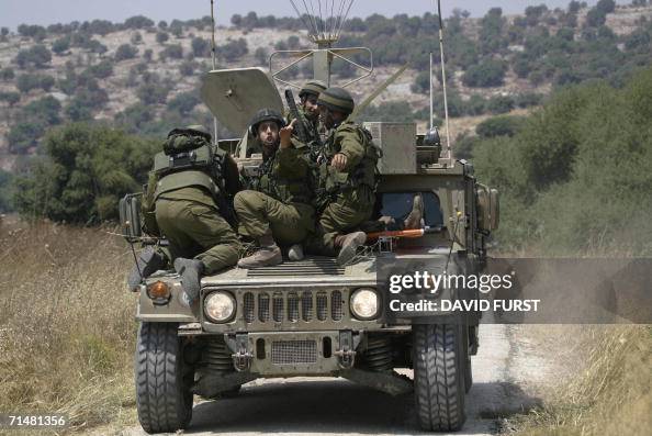 An Israeli soldier gestures as their Humvee armoured vehicle ferries ...