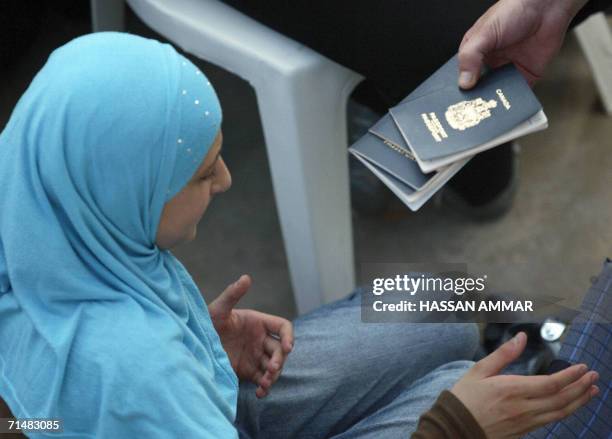 Official checks passports of Lebanese-born Canadian nationals to be evacuated in the southern Lebanese port city of Tyre 19 July 2006. A first...