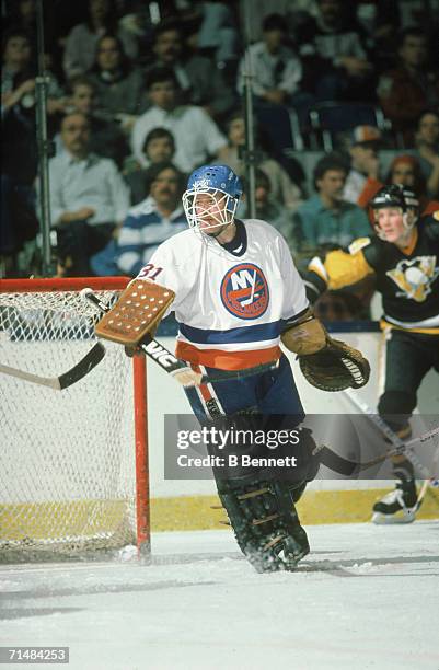 Canadian professional ice hockey player Billy Smith, goalie of the New York Islanders, on the ice during a home game against the Pittsburgh Penguins,...