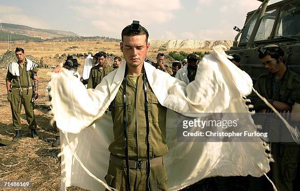 Israeli soldiers pray next to their 155mm artillery gun during the barrage against Hezbollah targets in South Lebanon on July 20, 2006 from a forward...