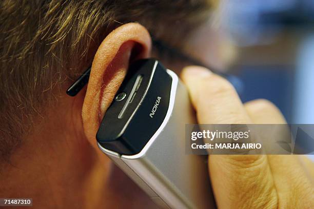 Dealer speaks on his Nokia mobile phone in Nordea Bank Finland's dealing room in Vallila Helsinki 20 July 2006. Nokia, the world's biggest mobile...