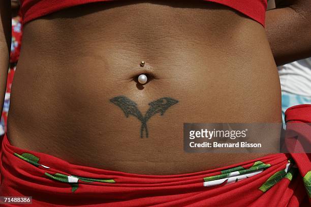 Tatoo detail and pierced navel is observed on the body of an Ocean Pacific Islander performer during the opening of 'Paris Plage' 2006 on July 20,...