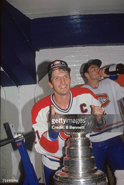 Canadian professional hockey player Guy Carbonneau , center for the Montreal Canadiens, poses with the Stanley Cup as he celebrates their...