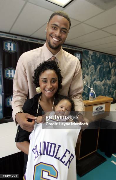 Tyson Chandler of the New Orleans/Oklahoma City Hornets wraps his new jersey around wife Kimberly and two-month-old daughter Sacha-Marie after a...