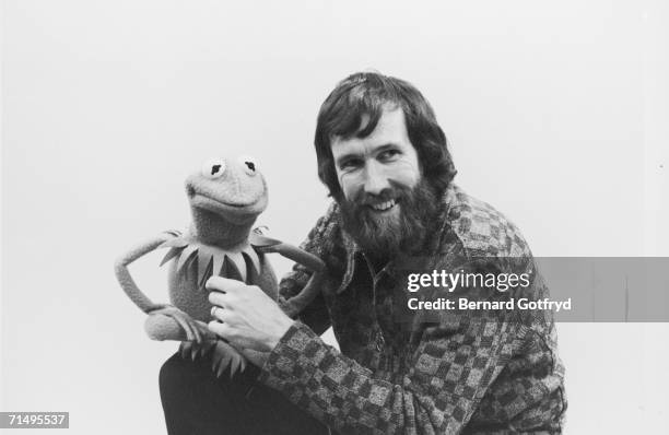 Portrait of American film & televison director and puppeteer Jim Henson as he holds muppet Kermit the Frog, late 1970s or early 1980s.