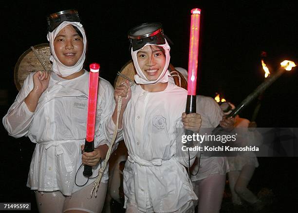 Japanese Amas, female divers, walk from the sea during the Shirahama Ama festival on July 21, 2006 in Shirahama, Japan. Amas dive to find shellfish...