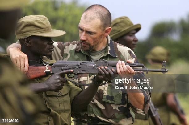 Former French special forces arms instructor Norbert Tible teaches a Congolese park ranger the use of an AK-47 assault rifle July 21, 2006 at Ishango...