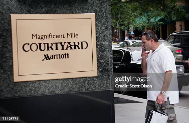 Smoker takes a final puff off of a cigarette before entering a Marriott Courtyard hotel near the Magnificent Mile shopping district July 21, 2006 in...