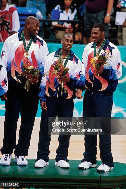 Shaquille O'Neal, Gary Payton, and Hakeem Olajuwon of the United States National Team proudly display their gold medals the Gold Medal Ceremony of...