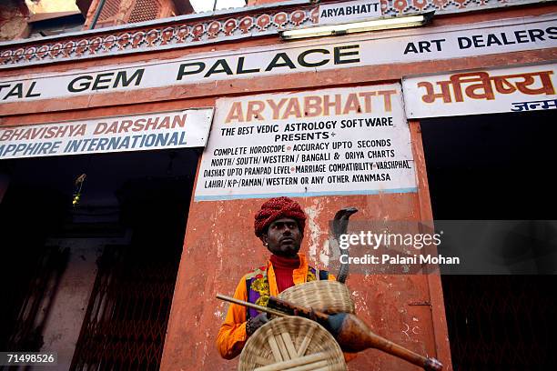 Snake handler with his snake out side a Gem shop on January 10, 2006 in Jaipur, India. Jaipur is famous for its precious and semi-precious stones. It...