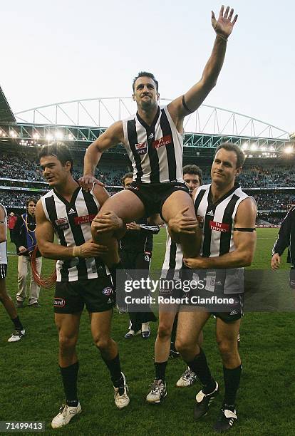 Anthony Rocca of the Magpies is chaired off the ground by teammates Chris Tarrant and James Clement after playing his 200th game at the round 16 AFL...