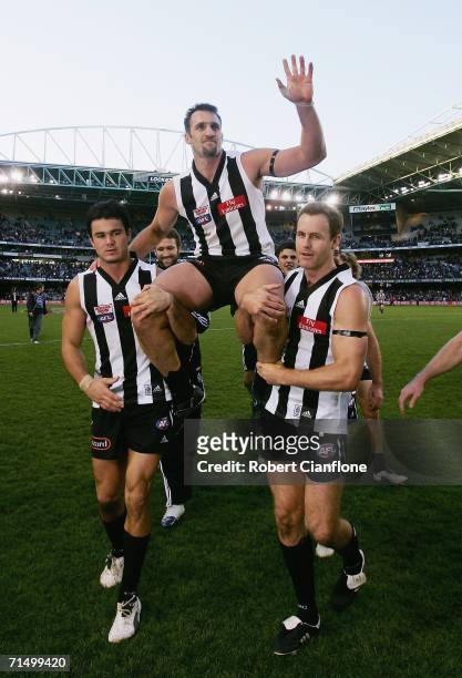 Anthony Rocca of the Magpies is chaired off the ground by teammates Chris Tarrant and James Clement after playing his 200th game, the round 16 AFL...