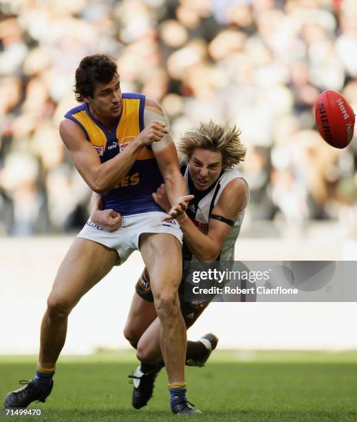 Andrew Embley of the Eagles is challenged by Dale Thomas of the Magpies during the round 16 AFL match between the Collingwood Magpies and the West...