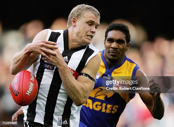 Tarkyn Lockyer of the Magpies gets to the ball ahead of David Wirrpanda of the Eagles during the round 16 AFL match between the Collingwood Magpies...