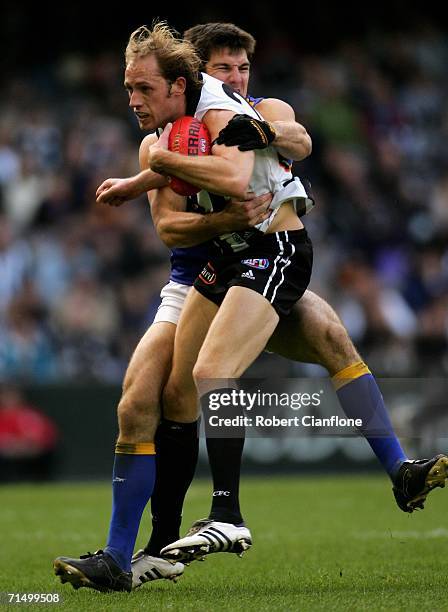 Josh Fraser of the Magpies is challenged by his opponent during the round 16 AFL match between the Collingwood Magpies and the West Coast Eagles at...