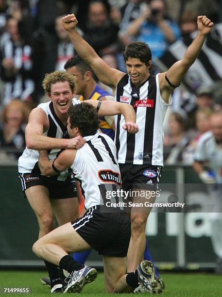 Ben Johnson, Shane O'Bree and Brodie Holland for Collingwood celebrate a goal during the round 16 AFL match between the Collingwood Magpies and the...