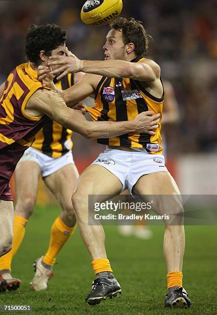 Brad Sewell of the Hawks is challenged by Michael Rischitelli of the Lions during the round 16 AFL match between the Brisbane Lions and the Hawthorn...