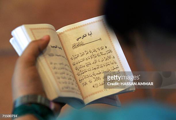 Displaced Lebanese woman from a border village in south Lebanon reads a copy of the Holy Quran at a hotel in the southern Lebanese port city of Tyre,...
