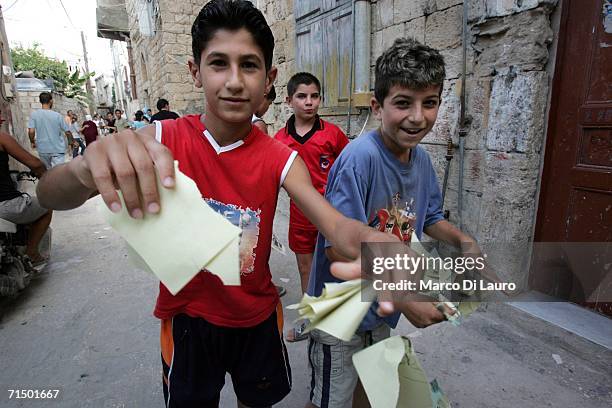 Lebanese children rip leaflets dropped by Israeli planes that read "Those protecting you are robbing you" July 22, 2006 in Tyre in southern Lebanon....