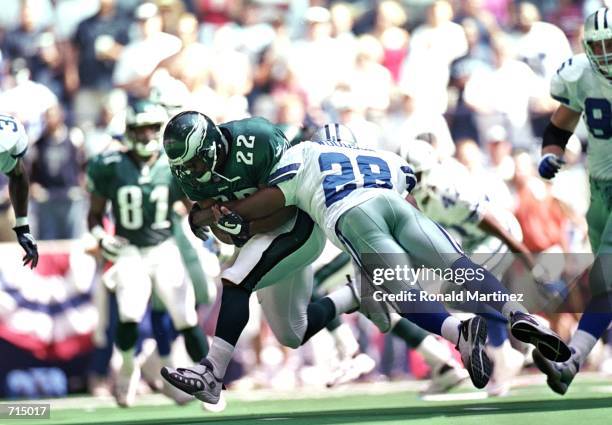 Darren Woodson of the Dallas Cowboys tackles Duce Staley of the Philadelphia Eagles during the game at the Texas Stadium in Irving, Texas. The Eagles...