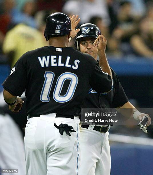 Frank Catalanotto and Vernon Wells of the Toronto Blue Jays celebrate their runs scored for a 4-2 lead against the New York Yankees during the fifth...