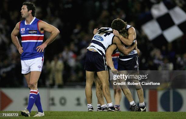 Rohan Smith of the Bulldogs looks on dejected as Corey Enright, Gary Ablett and Jarad Rooke of the Cats celebrate their teams win during the round 16...