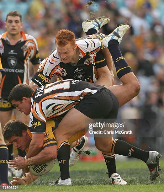 Josh Cordoba of the Eels is up ended by the Tigers defence during the round 20 NRL match between the Wests Tigers and the Parramatta Eels played at...