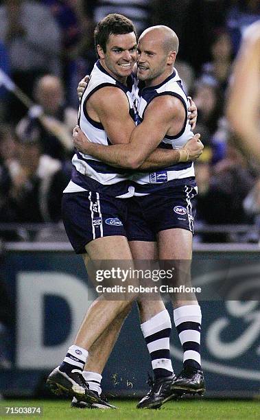 Matthew Scarlett and Paul Chapman of the Cats celebrate a goal during the round 16 AFL match between the Geelong Cats and the Western Bulldogs at the...