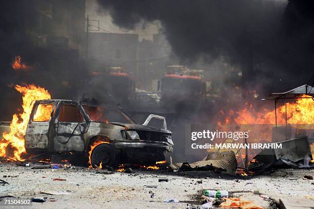 Trucks and cars burn in front of a courthouse in the northern Iraqi oil city of Kirkuk 23 July 2006. A car bomb killed 15 people and injured 50 more,...