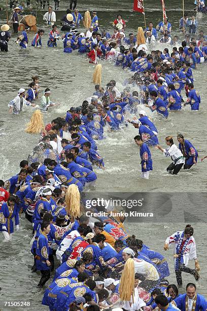 People in traditional dress pull wood along the Isuzu River to the Inner Shrine of Japan's biggest shrine ?Ise Jingu? during the 62nd Okihiki-Gyoji...