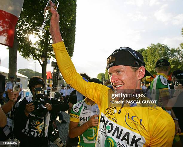 Yellow jersey USA's Floyd Landis drinks a glass of champain to celebrate his victory after the 154.5 km twentieth and last stage of the 93rd Tour de...