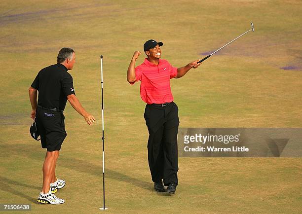 Tiger Woods of USA celebrates victory on the 18th green as his caddy Steve Williams looks on at the end of the final round of The Open Championship...