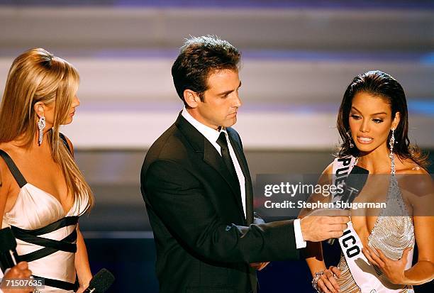 Show hosts Nancy O'Dell and Carlos Ponce listen to Miss Puerto Rico Zuleyka Rivera Mendoza give her response to the interview question on stage...