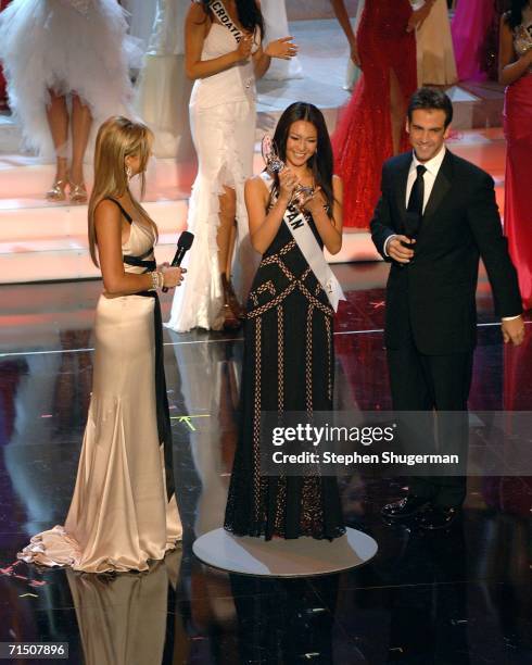 Miss Japan Kurara Chibana is given the "Best National Costume" award by show hosts Nancy O'Dell and Carlos Ponce during the Miss Universe 2006...