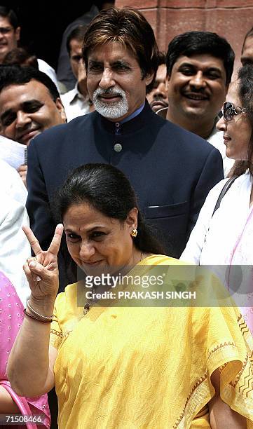 Member of the Rajya Sabha, the Upper House of Parliament, Jaya Bachan shows a victory sign as her film-star husband Amitabh Bachchan looks on during...