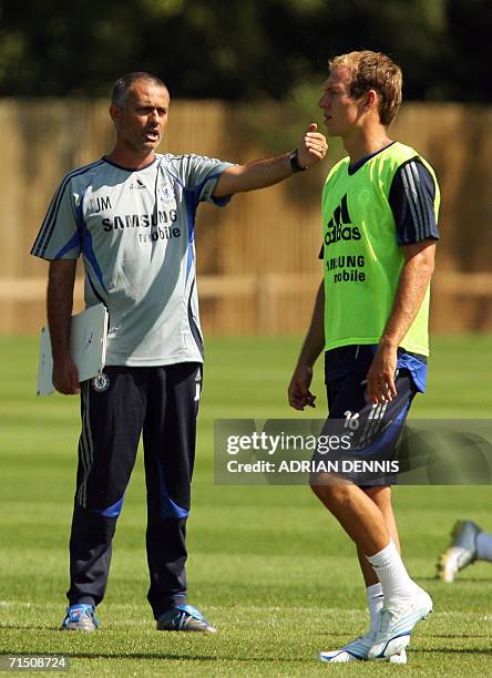 Cobham, UNITED KINGDOM: Chelsea Portuguese manager Jose Mourinho gestures while Dutch striker Arjen Robben walks past during a team training session...