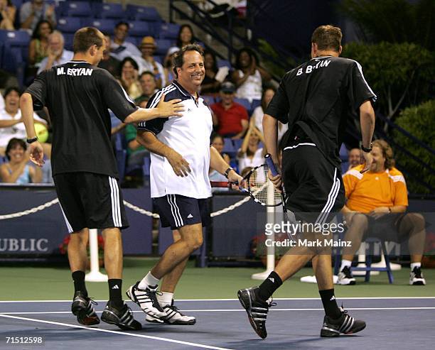 Tennis players Mike Bryan and Bob Bryan congratulate celebrity player Jon Lovitz after winning a game during the Gibson/Baldwin "Night At The Net"...