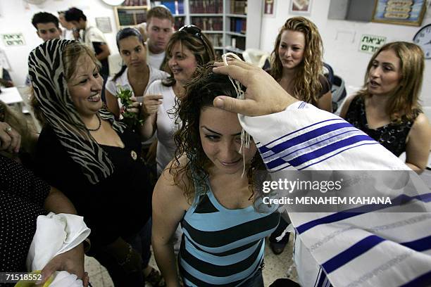 Relatives are blessed during the circumcision ceremony of eight day-old baby Ofir Hen in a bomb shelter at the Tirat Carmel neighborhood near the...