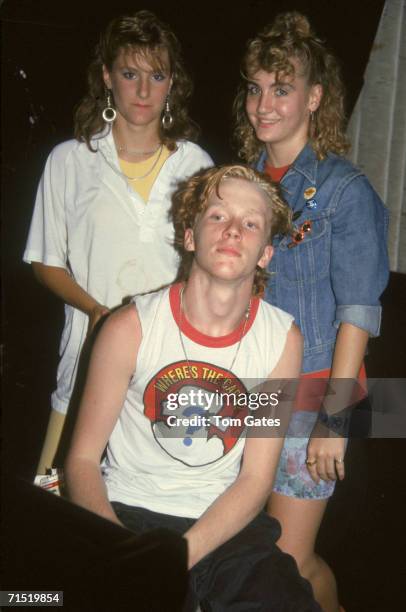 American actor Anthony Michael Hall poses for a photograph as he sits in a sleeveless Cap'n Crunch t-shirt before two teenaged girls at the...