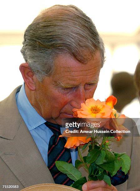 Prince Charles, Prince of Wales smells flowers while visiting the Sandringham Flower Show on July 26, 2006 in Sandringham, Norfolk, England.